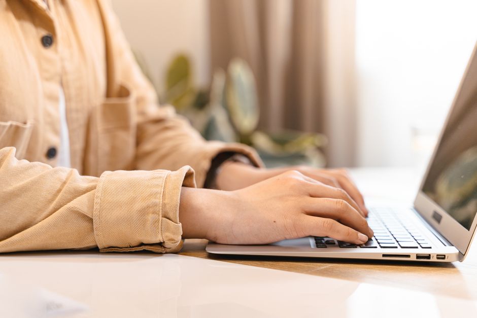 Close-up of hands typing commands on a laptop keyboard